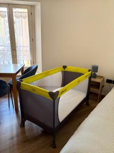 a yellow and black bed in a room with a table at Casa Polly in Rovereto +1 photo
