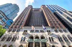 a tall building with two american flags in front of it at Warwick Allerton Chicago in Chicago