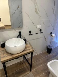 a bathroom with a white sink on a wooden table at DOMUS Puteoli in Pozzuoli