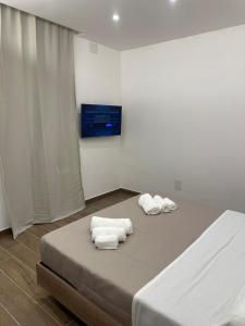 a bedroom with a bed with towels on it at DOMUS Puteoli in Pozzuoli