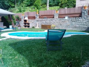 a chair sitting in the grass next to a swimming pool at A Casa Do Viso Do Chirin in Ponteareas