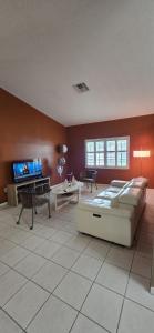 a large living room with a bed and a flat screen tv at Across from Sawgrass Mall- Next to Amerant Bank Arena in Sunrise
