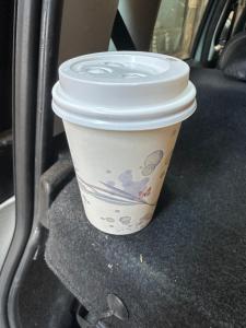 a cup of coffee sitting on the seat of a car at DOMUS Puteoli in Pozzuoli