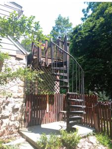 a wooden gate with a wooden staircase behind a fence at Magical stone cottage in Pine Grove Mills