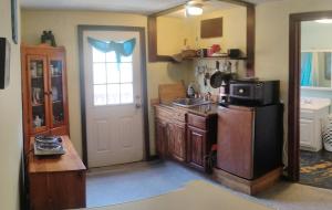a kitchen with a sink and a refrigerator at Magical stone cottage in Pine Grove Mills