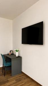 a room with a table and a television on a wall at Infinity Blue in Cefalù