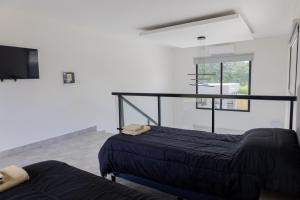 a bedroom with two beds and a tv in a room at Almería Suites in Salta