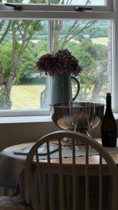 a table with a vase with flowers and a window at The Loft in Cookstown Junction +14 photos