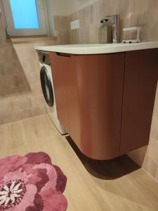 a washing machine in a bathroom with a rug at Arte Golf Apartment in Kuressaare +22 photos