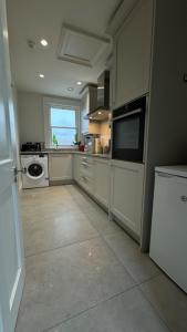 a large kitchen with white cabinets and a window at The Loft in Cookstown Junction