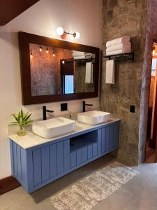 a bathroom with two sinks and a large mirror at Gaia Hotelaria in Teresópolis +28 photos