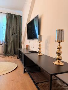 a living room with a black desk with a flat screen tv at LevelUp Comfort in Koblenz