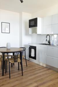 a kitchen and dining room with a table and a sink at Malé Lipno 1075 in Černá v Pošumaví