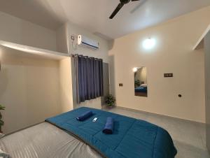 a bedroom with a bed with a blue blanket on it at Galaxy Homestay 4Bhk AC in Mysore