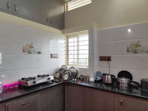 a kitchen with a stove and a counter top at Galaxy Homestay 4Bhk AC in Mysore
