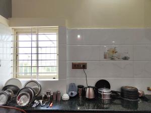 a kitchen with a counter top with pots and pans at Galaxy Homestay 4Bhk AC in Mysore
