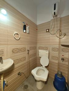a bathroom with a toilet and a sink at Galaxy Homestay 4Bhk AC in Mysore +15 photos