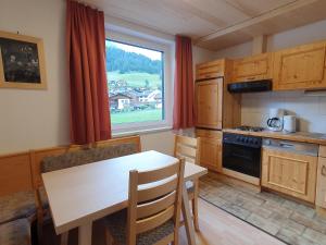 a kitchen with a table and a table and a window at Ferienhaus Tirolerhof in Kals am Großglockner