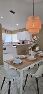 a kitchen with a table with chairs and a dining room at Across from Sawgrass Mall- Next to Amerant Bank Arena in Sunrise