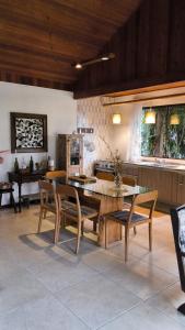 a dining room with a table and chairs and a kitchen at Refúgio Orquídea Bambu - Lumiar in Nova Friburgo