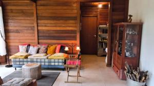 a living room with a couch with colorful pillows at Refúgio Orquídea Bambu - Lumiar in Nova Friburgo