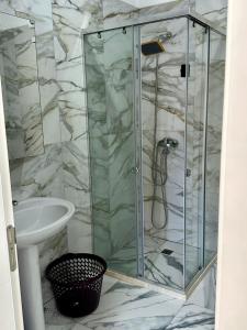 a shower with a glass door next to a sink at Sea flavor 2 in Shëngjin +81 photos