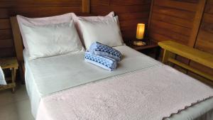 a bed with a pillow sitting on top of it at Refúgio Orquídea Bambu - Lumiar in Nova Friburgo