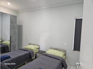 two beds in a room with a mirror at Residence Niko 5 Pomezia in Pratica di Mare
