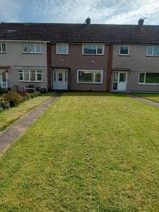 a large yard in front of a brick house at Martindale Close - 3 Bedrooms - Sleeps 5 in Whitehaven