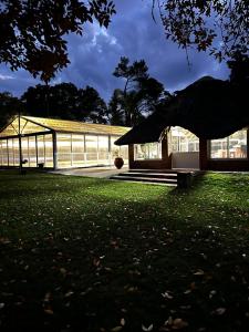 a large building with a grass field in front of it at Posada de Campo San Cono in Mercedes