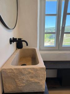 a bathroom with a stone sink and a mirror at Mirca with seaview - charming stonehouse in Mirce +30 photos