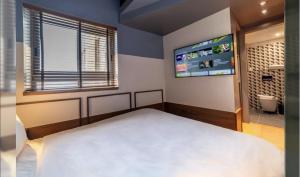 a bedroom with a bed and a flat screen tv at HYVE Jerusalem hosted by STAY in Jerusalem +74 photos