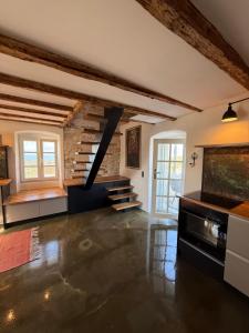 a large living room with a staircase and a brick wall at Mirca with seaview - charming stonehouse in Mirce