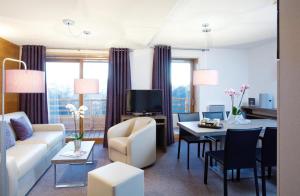 a living room with a couch and a table at Alpenrose Alpe d'Huez in LʼHuez
