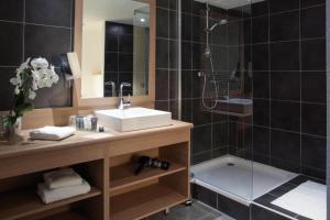 a bathroom with a sink and a shower at Alpenrose Alpe d'Huez in LʼHuez