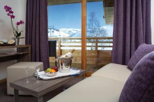 a hotel room with a table with a tray of fruit on a table sidx sidx at Alpenrose Alpe d'Huez in LʼHuez