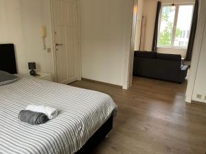 a bedroom with a bed and a living room with a couch at Cosy uccle chic flat in Brussels