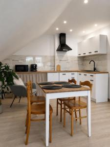a kitchen with a table and chairs in a kitchen at Pokoje i apartamenty Mak in Łeba