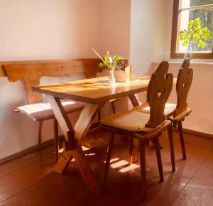 a wooden table and two chairs with a wooden table and a table at Zámeček Bischofstein in Teplice nad Metují