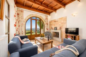 a living room with two blue couches and a fireplace at Villa Top Hill in Agia Triada