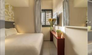a small bedroom with a bed and a window at HYVE Jerusalem hosted by STAY in Jerusalem
