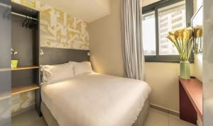 a small bedroom with a white bed and a window at HYVE Jerusalem hosted by STAY in Jerusalem