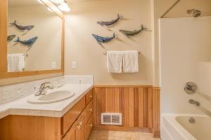 a bathroom with a sink and a mirror and a tub at A Mermaids Dream in Pacific City +34 photos