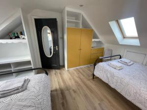a attic bedroom with two beds and a mirror at Wild Atlantic View in Walshestown