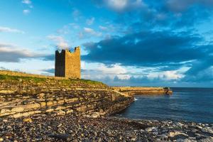 a castle on a cliff next to the water at Wild Atlantic View in Walshestown