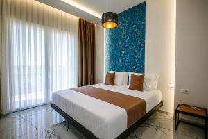 a bedroom with a large bed with a blue wall at Olive Farmhouse in Hamallë