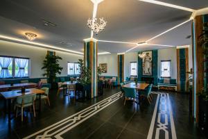 a restaurant with tables and chairs and a chandelier at Olive Farmhouse in Hamallë