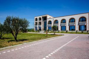 an empty road in front of a building at Olive Farmhouse in Hamallë