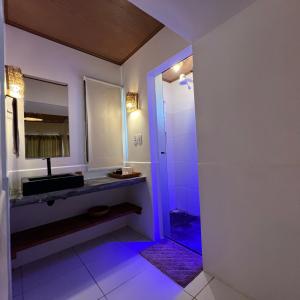 a bathroom with a sink and a shower with purple lights at Vila Capininga Ecopousada in Santo Amaro +105 photos