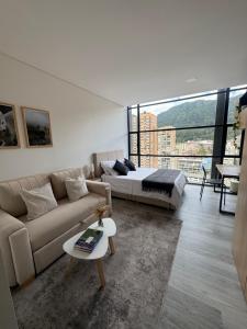 a living room with a couch and a bed at Diseño, vistas Monserrate WiFi 300Mb in Bogotá